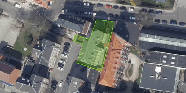 Satellitbillede med ejendommens grund markeret med grønt